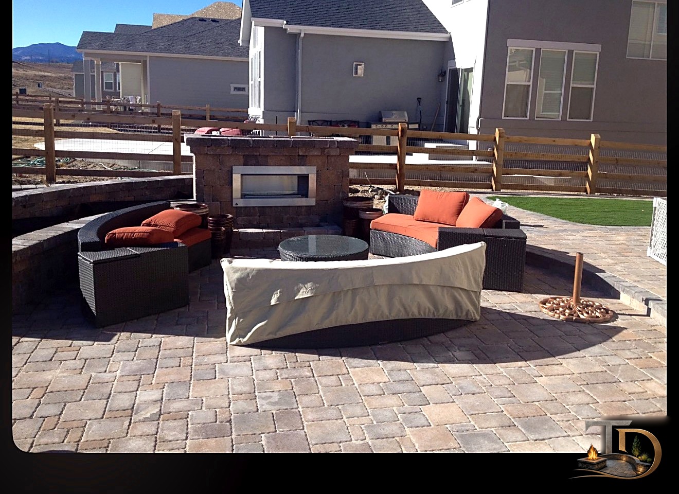 Paver patio with circular fire pit and curved seat wall