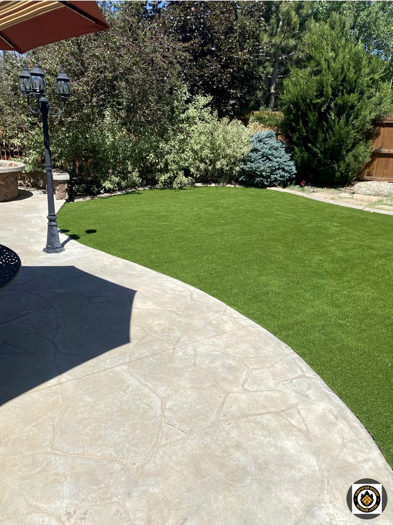 Artificial turf backyard with stamped concrete patio