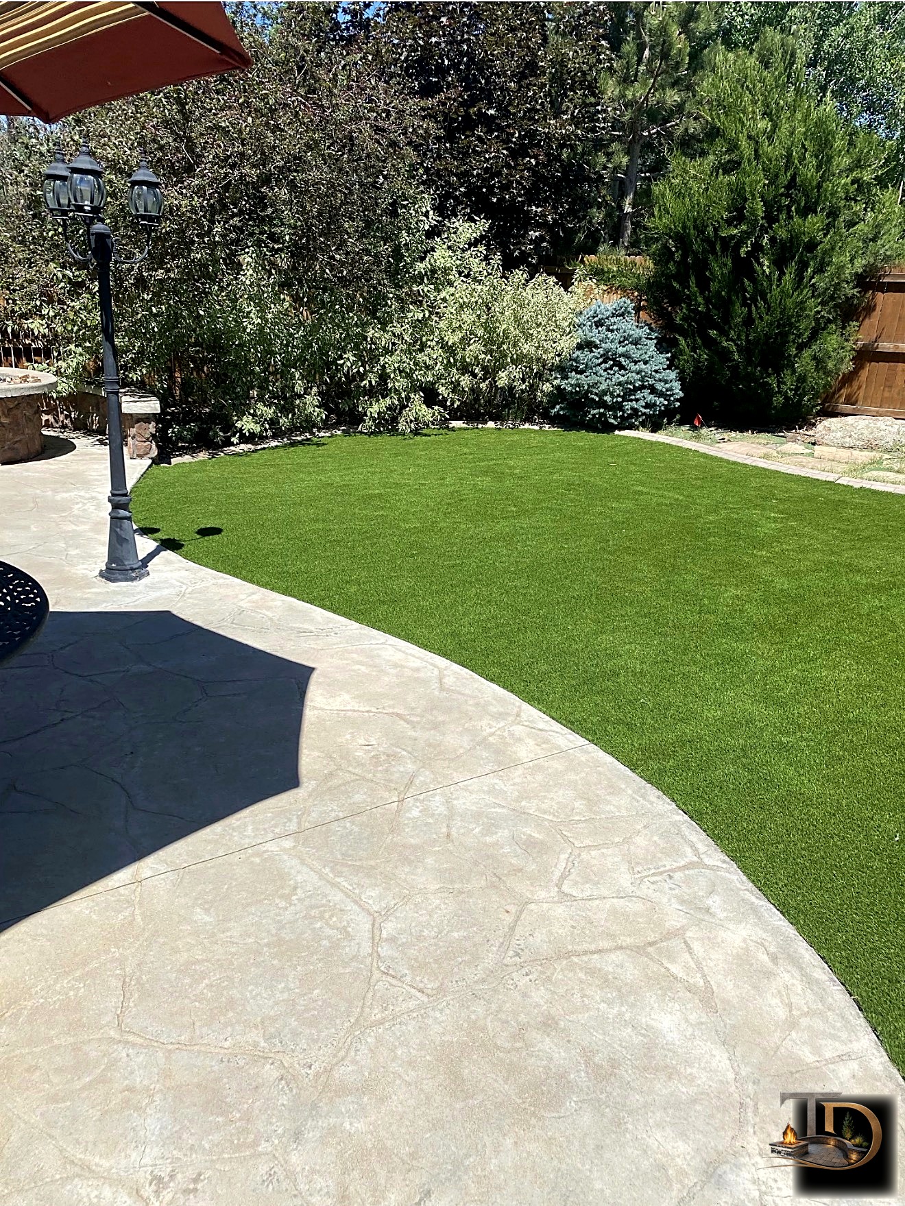 Artificial turf backyard with stamped concrete patio