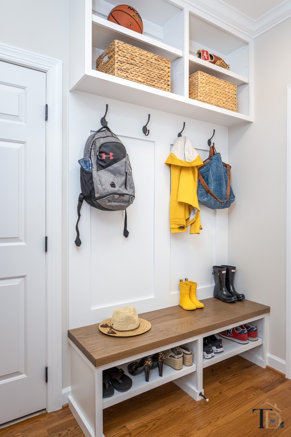 An organized entryway bench with hooks, baskets, and a spot for every coat, bag, and pair of shoes